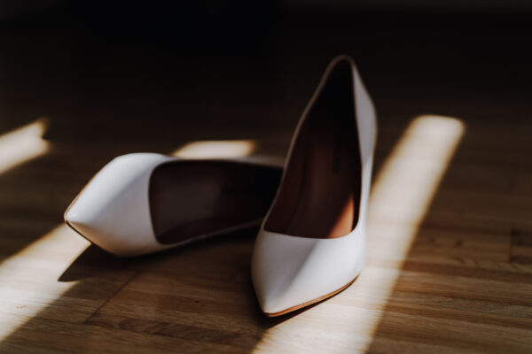 Schuhe einer Braut in warmem Sonnenlicht, auf dem Boden ausgestellt